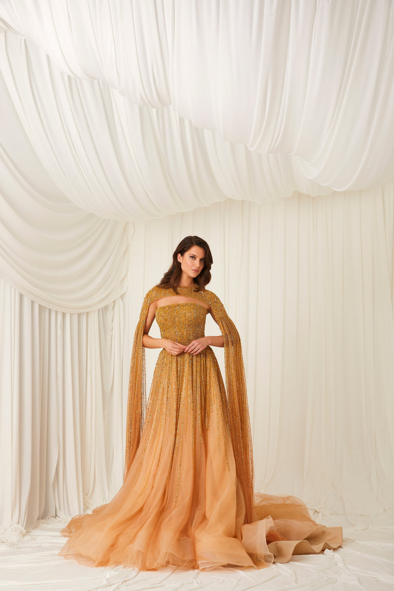 Li Beirut M1002 – Strapless Embellished Gold Ball Gown with Beaded Cape Overlay