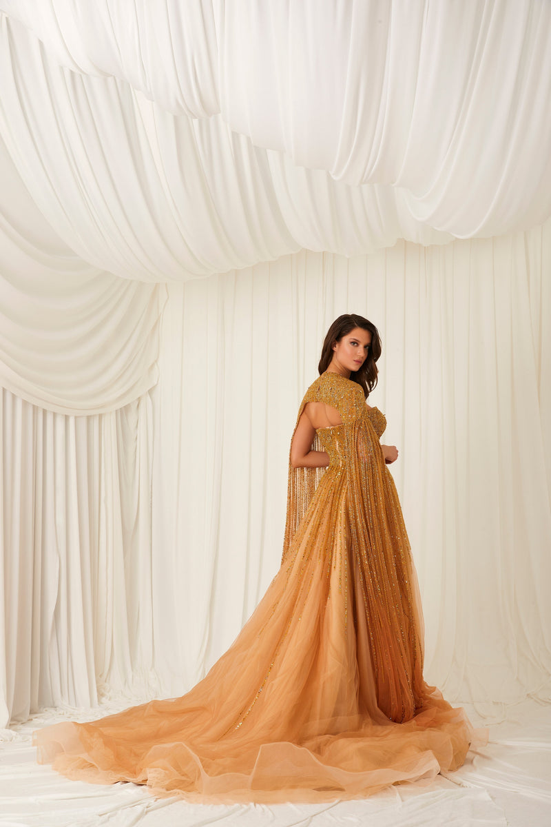 Li Beirut M1002 – Strapless Embellished Gold Ball Gown with Beaded Cape Overlay