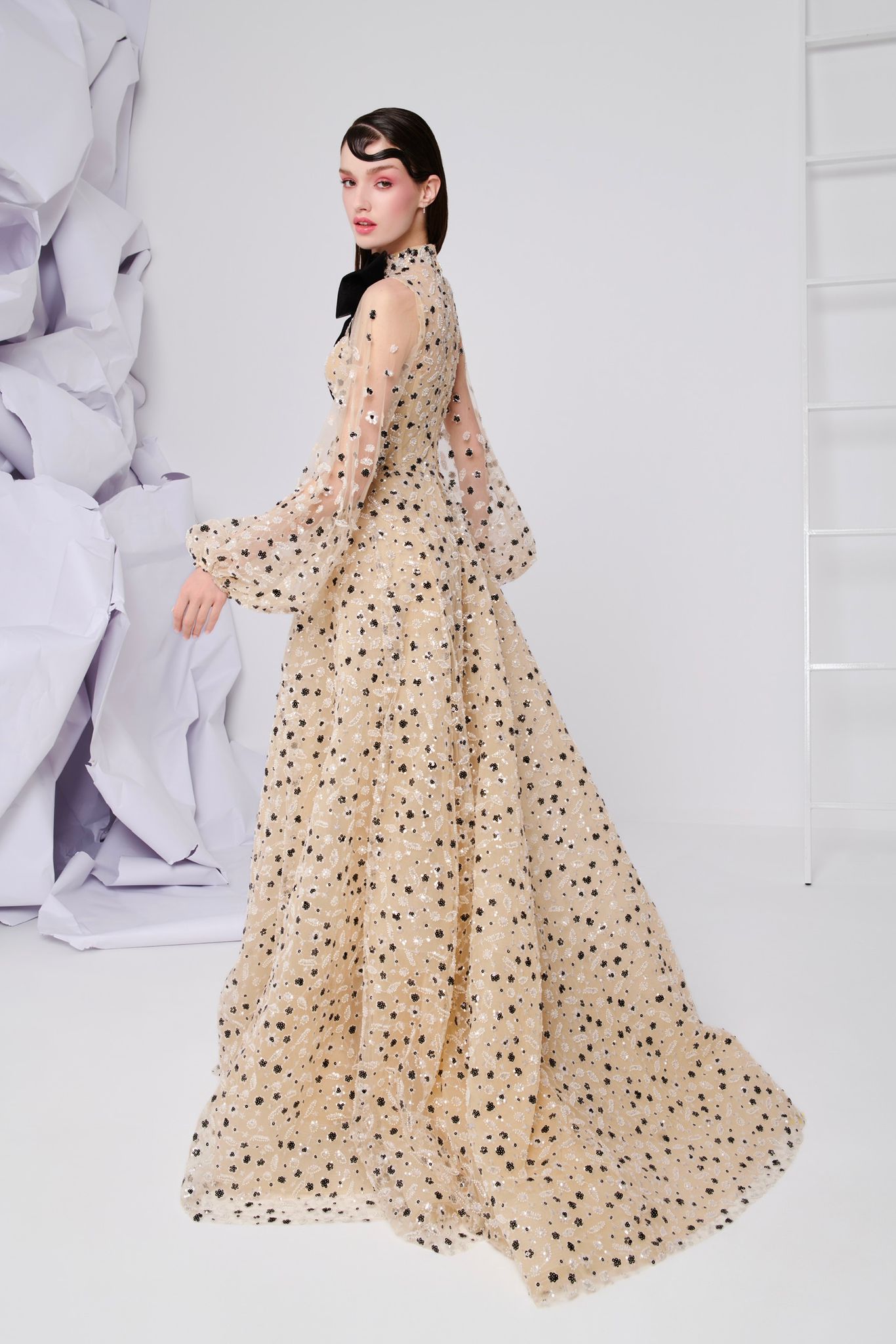 Li Beirut M1104 – High-Neck Illusion Gown with Floral Embellishments, Statement Bow & Sheer Sleeves