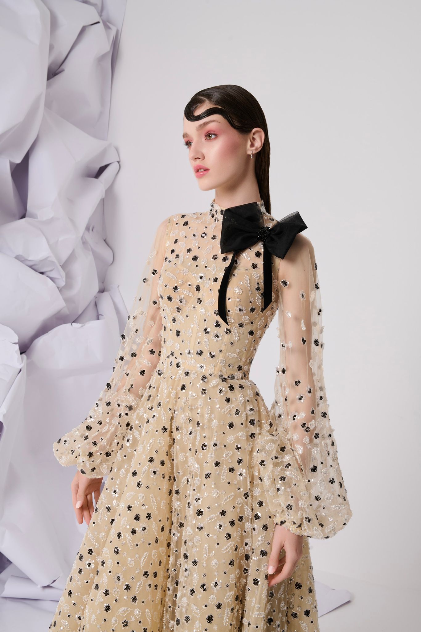 Li Beirut M1104 – High-Neck Illusion Gown with Floral Embellishments, Statement Bow & Sheer Sleeves