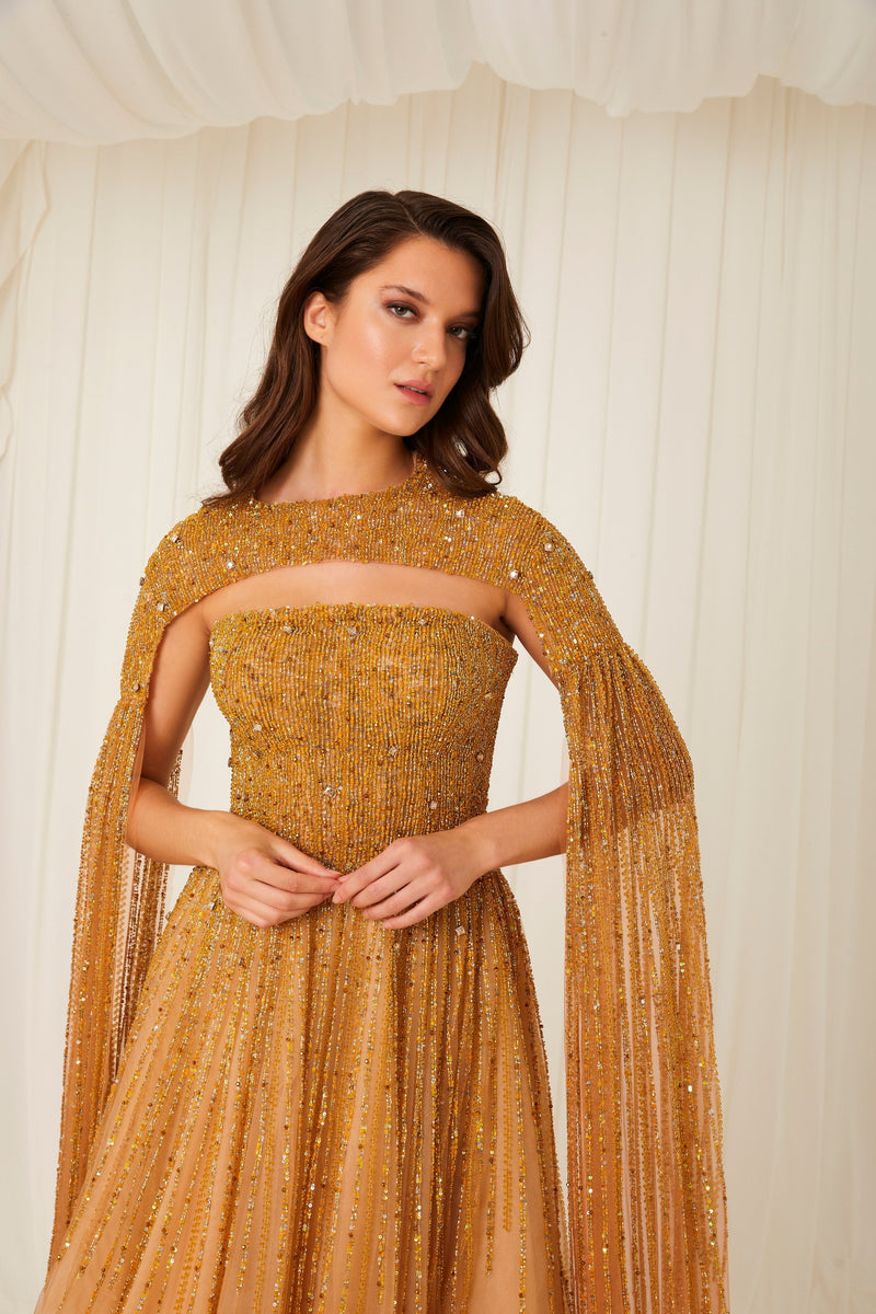 Li Beirut M1002 – Strapless Embellished Gold Ball Gown with Beaded Cape Overlay