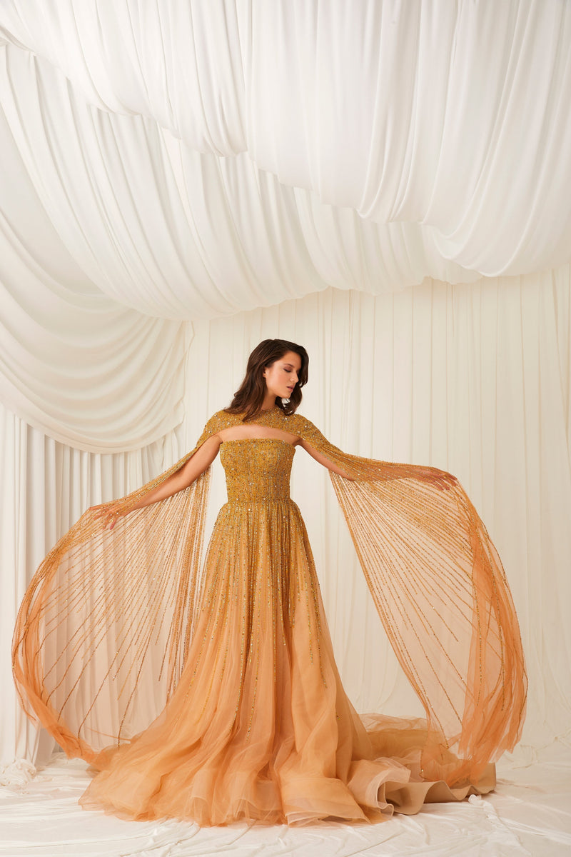 Li Beirut M1002 – Strapless Embellished Gold Ball Gown with Beaded Cape Overlay