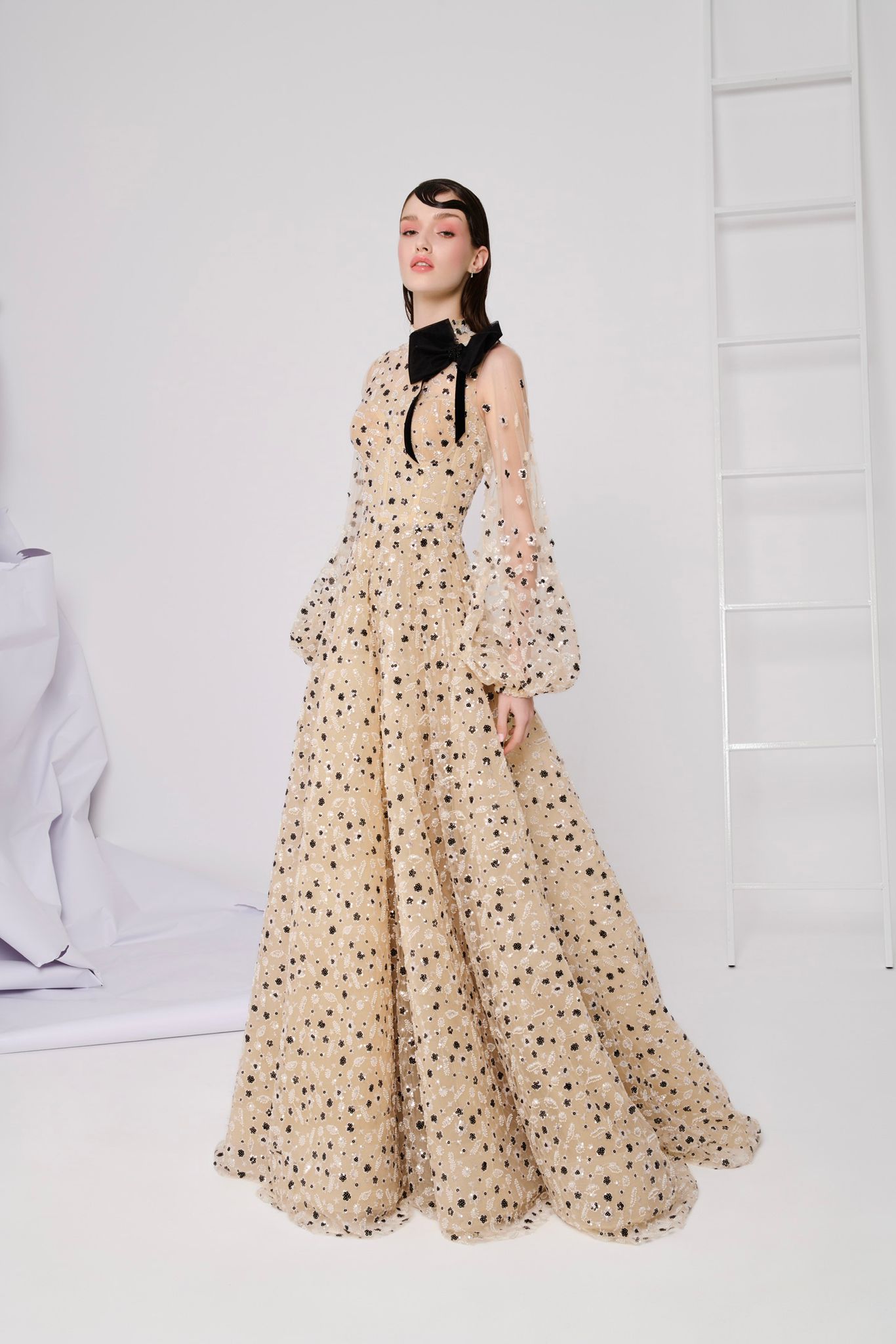 Li Beirut M1104 – High-Neck Illusion Gown with Floral Embellishments, Statement Bow & Sheer Sleeves