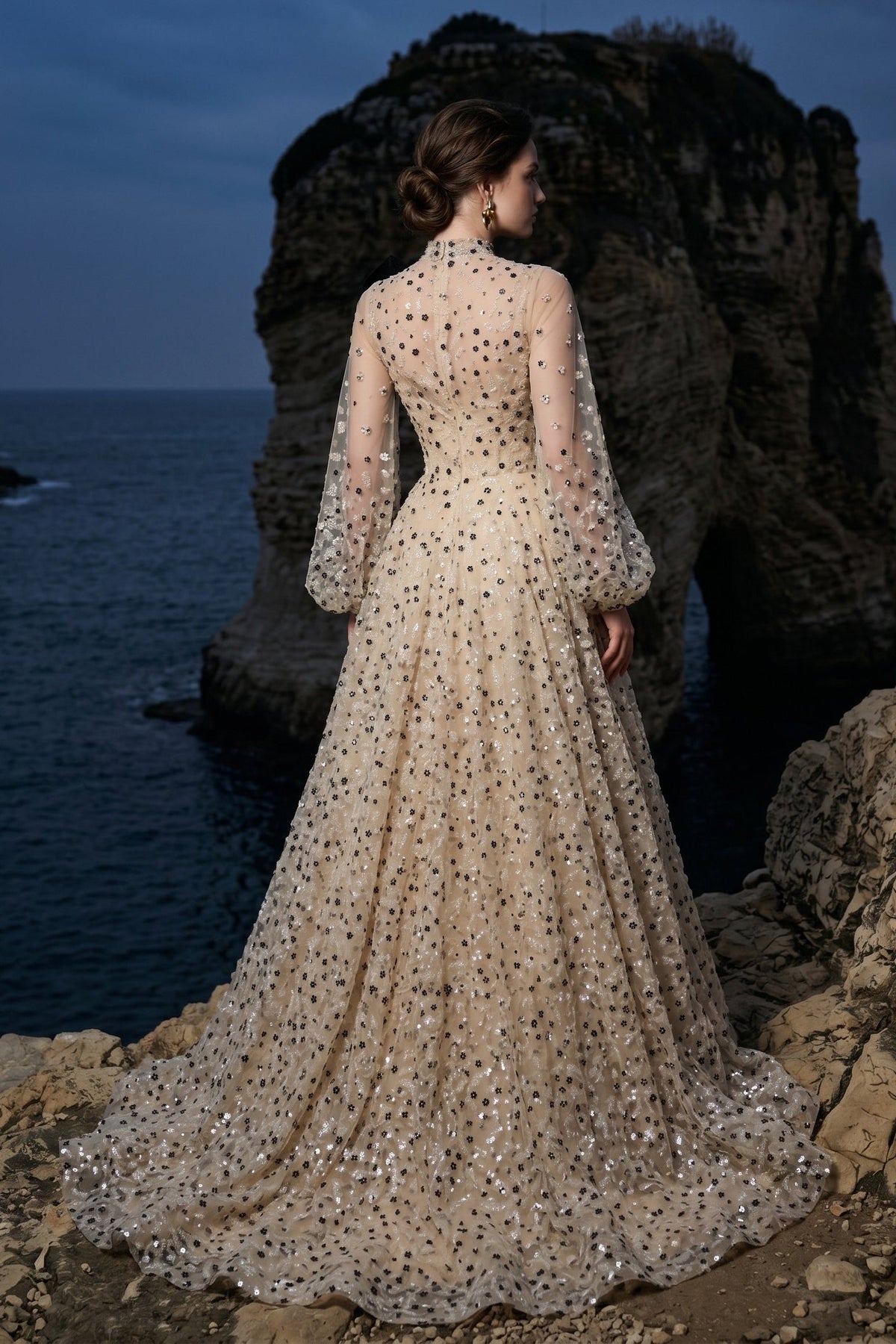 Li Beirut M1104 – High-Neck Illusion Gown with Floral Embellishments, Statement Bow & Sheer Sleeves