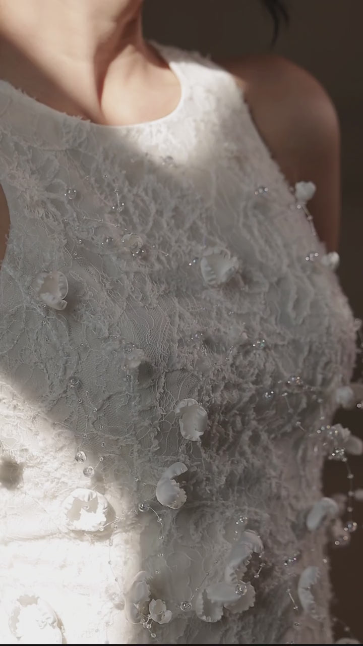 ARTI APPAREL close-up of raised white floral embroidery on the dress bodice.