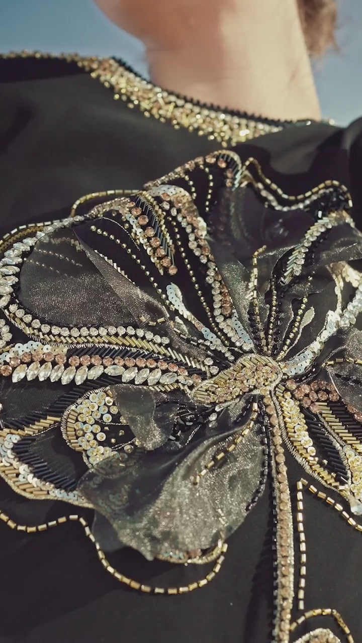 CHANCOS close-up of floral beadwork on the black gown.